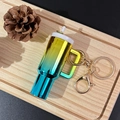 Gradient tumbler keychain in yellow, green, and blue with golden clasp on wooden tray - Gradient Gold Green