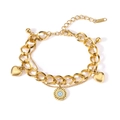 Détail d'un bracelet double chaîne doré avec des pendentifs cœur et œil grec - Bracelet Double Couche Œil du Mal et Cœur Doré
