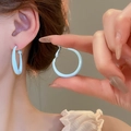 Dettaglio di orecchini a cerchio azzurro con finitura opaca e effetto indossato sul lobo - Cerchio Piccolo Smalto Opaco Blu Chiaro (23#) / Blu-Piccolo 3cm