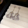 Macro shot of silver tassel earrings with hollow gourd shape and cubic zirconia inlay - Zircon Flower Gourd Tassel Earrings