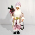 Detailopname van een roze kerstmanfiguur met pailletten en een vintage lantaarn - Exquise Editie / Roze