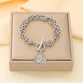 Dettaglio di un bracciale multistrato in acciaio argento con chiusura OT e ciondolo - Placca Rotonda Ritratto Argento (KB210184-Z)