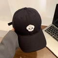 Black cotton baseball cap featuring a white Bichon Frise embroidery on a wooden table - Adjustable / Black/Bichon Embroidery