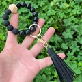 Details von Perlenarmband-Schlüsselanhänger mit schwarzen Perlen und Lederquaste in der Hand - Schwarze Lederquaste mit schwarzen Marmormuster-Perlen (Stil 25)