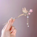 Dettaglio di un fermaglio dorato con farfalle, fiori rosa e nappe di perle - Rosa