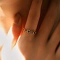 Close-up of a 18K gold ring featuring three round blue sapphires on a model's hand - Adjustable Open / Blue (KR0040-1)