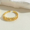 Close-up of gold chain link ring with sparkling zircons on minimalist stone background - Intertwined Chain Style / White Zirconia