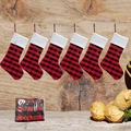 Set mit sechs rot-schwarz karierten Weihnachtsstrümpfen vor rustikalem Holzhintergrund - Rotes Karo