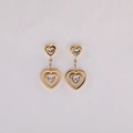 Detail of gold heart earrings featuring hollow pendants and clear zircon stone settings - Gold White Zirconia