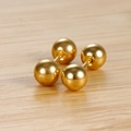Minimalistische vergoldete Edelstahl-Kugelohrstecker auf einem Holzhintergrund - 5mm Gold