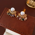 Detalle de pendientes vintage con perlas blancas y borlas de cuentas de colores en cuero - Poste de pendiente de plata - Colorido