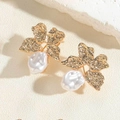 Detail of floral gold earrings with white pearls on a textured stone surface - Gold Flower Style (ES2430-1)