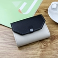 Short tri-fold wallet in black and beige contrast leather with daisy buckle detail - Black