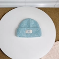 Detailed texture of light blue knitted wool hat with white BAKE label for kids - Approx. 3-8 Years / Lake Blue