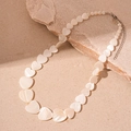 Macro shot of heart-shaped pearlescent beads on a shell-style necklace with silver clasp - White Heart Shell Necklace