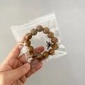 Portable PVC clear jewelry pouch containing a brown wooden beaded bracelet with knot - 30 Micron 13x13cm Resealable / 100 Pcs/Pack