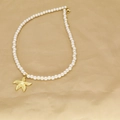Detail of beaded necklace featuring white faux pearls and a golden starfish charm - Simple Pearl Starfish (H)