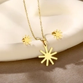 Detailed shot of golden sunburst necklace and earrings set on a white ceramic tray - Sunburst (TZ-418)