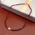 Vista detallada del collar de granate con perla central y cadena de extensión dorada - Rojo (Caja de Regalo)