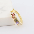 Vista macro de un anillo ajustable dorado con piedras de circonita de colores en corazón - Circón de Colores en Corazón