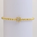 Detail of gold beaded elastic bracelet featuring a micro-paved cubic zirconia letter K charm - Letter K