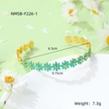 Detailed view of daisy open cuff bracelet in gold finish with green enamel petals - Dark Blue Bracelet