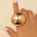 Gros plan d'une bague sphérique dorée surdimensionnée avec une finition miroir polie - Or Grosse Sphère Polie