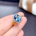 Luxurious gold-tone ring featuring a vibrant blue oval gemstone with accent stones - Adjustable Open / Sea Blue Stone (Gold Tone)