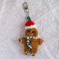 Detail van een handgehaakte peperkoekman sleutelhanger met kerstmuts en rood hartje - Peperkoekman (Sjaalstijl)