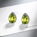 Teardrop cut lemon green zircon stud earrings in silver beaded setting on a display card - Olive Green Zirconia