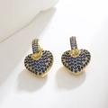 Close-up of gold earrings featuring heart charms encrusted with blue crystals - Blue