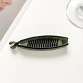 Close-up of black plastic banana hair clip with internal teeth for secure ponytail grip - Green