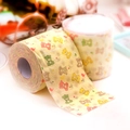 Two rolls of cream-colored toilet paper featuring colorful cartoon bear and heart patterns - Bear