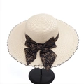 Detailed texture of summer straw hat with wide brim, lace trim and bow ribbon on a stand - M (56-58cm) / Beige