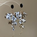 Detailansicht der Leoparden-Stoffblumen-Ohrringe mit Goldketten und schwarzem Edelstein - Weiß