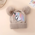 Close-up of beige knit baby hat featuring embroidered unicorn and fluffy double pom-poms - One Size (1-4Y) / Unicorn - Khaki