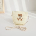 Detaillierte Makroansicht einer süßen Häkelbär-Applikation auf einer cremefarbenen Strohtasche - 48-52cm / Geflochtene Umhängetasche / Creme