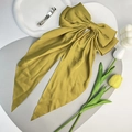Vue détaillée de la grande pince à cheveux en satin jaune moutarde avec rubans longs. - Curcuma
