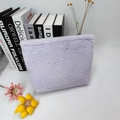 Detalle de neceser de felpa lavanda con textura de pelo sintético y cremallera - Lavanda