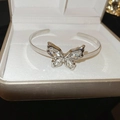 Detail of silver butterfly open bangle with sparkling cubic zirconia on a jewelry box - Silver