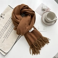 Soft brown pashmina style scarf with fringe tassels neatly folded on a white surface - Caramel