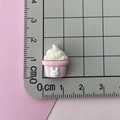 Detail view of pink resin cupcake charm with white rabbit relief on a scale mat - Rabbit Ice Cream/Cupcake