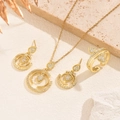 Elegant gold jewelry set with teardrop zircons on a textured stone background - Gold Yellow
