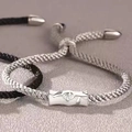 Macro detail of silver rose charm on a grey woven rope bracelet for couples - Silver Grey-Female