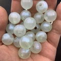 Detailed view of luminous glitter resin beads for DIY bracelets shown in a hand - 16mm / Green