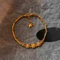 Bracciale in bambù placcato oro 18K con zirconi e perline su pietra scura - Oro