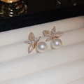 Macro shot of elegant gold-plated pearl earrings with sparkling diamond accents - Gold - White Flower Pearl (40# Silver Needle)