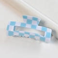 Detailed top view of a blue and white checkered acetate claw clip on neutral fabric - Blue White Checkerboard Rectangular Claw