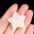 Star-shaped natural rose quartz stone held in hand with polished smooth finish - White Crystal