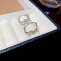 Macro shot of silver geometric hoop earrings with zircon stones on white velvet - Silver Hoop / Silver